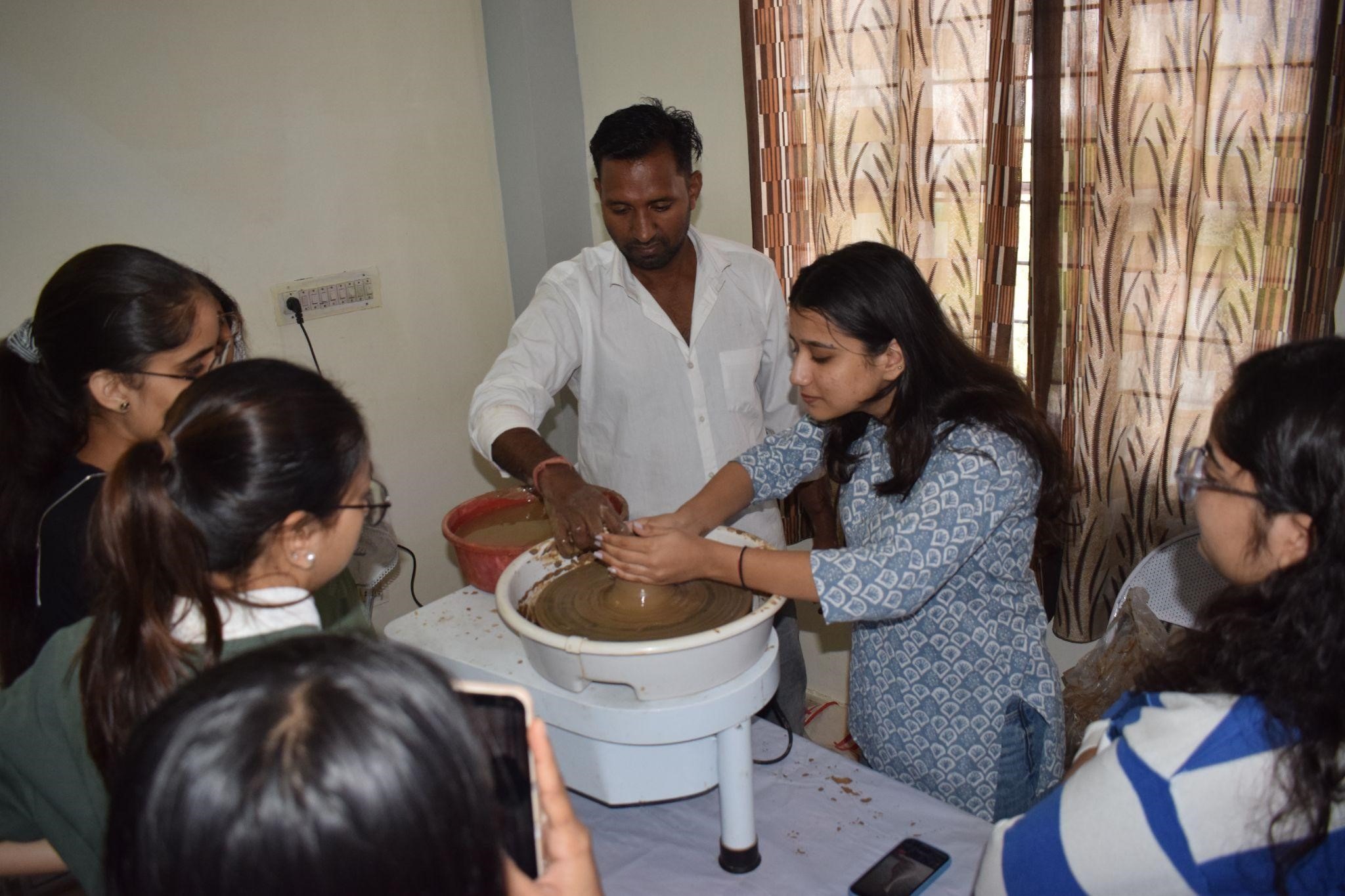 training students in exploring different techniques of working on the wheel and with the clay.