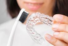 close-up-woman-showing-how-to-clean-clear-aligner