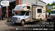 A Class C Motorhome outside of a workshop, showing it's Slide-Out