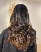 Professional hairstylist applying hair color to a client in a modern New York City salon, highlighting expert hair coloring and personalized salon care.